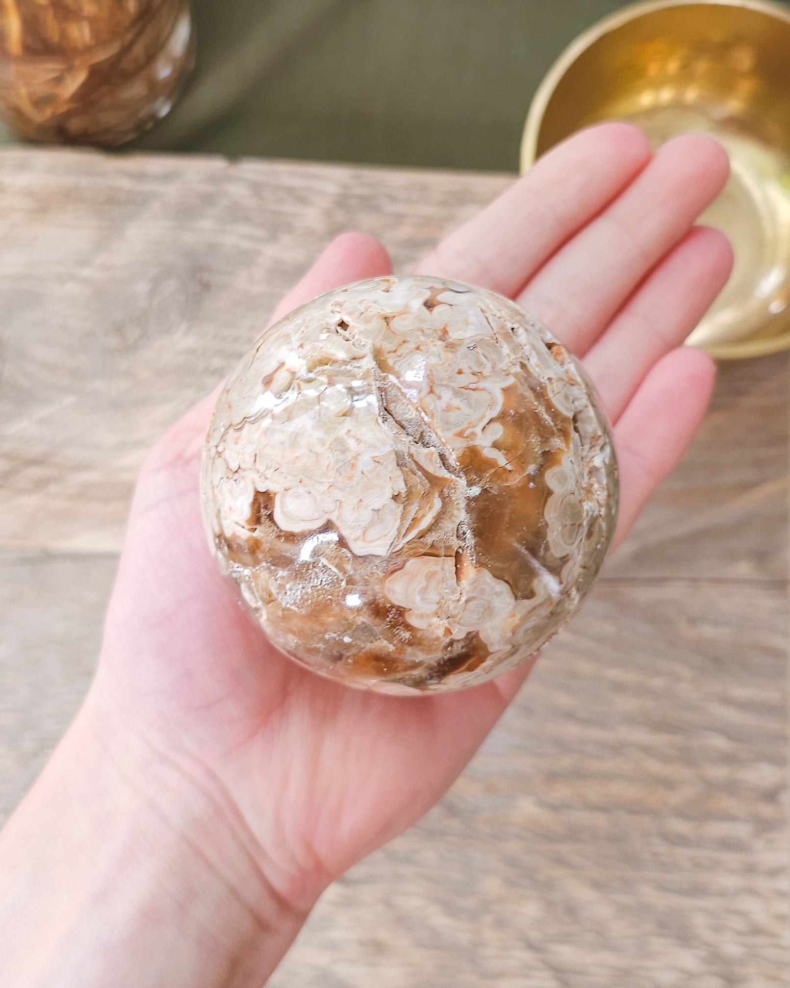 Handheld Chocolate Calcite sphere with natural druzy crystals and intricate orbicular formations.