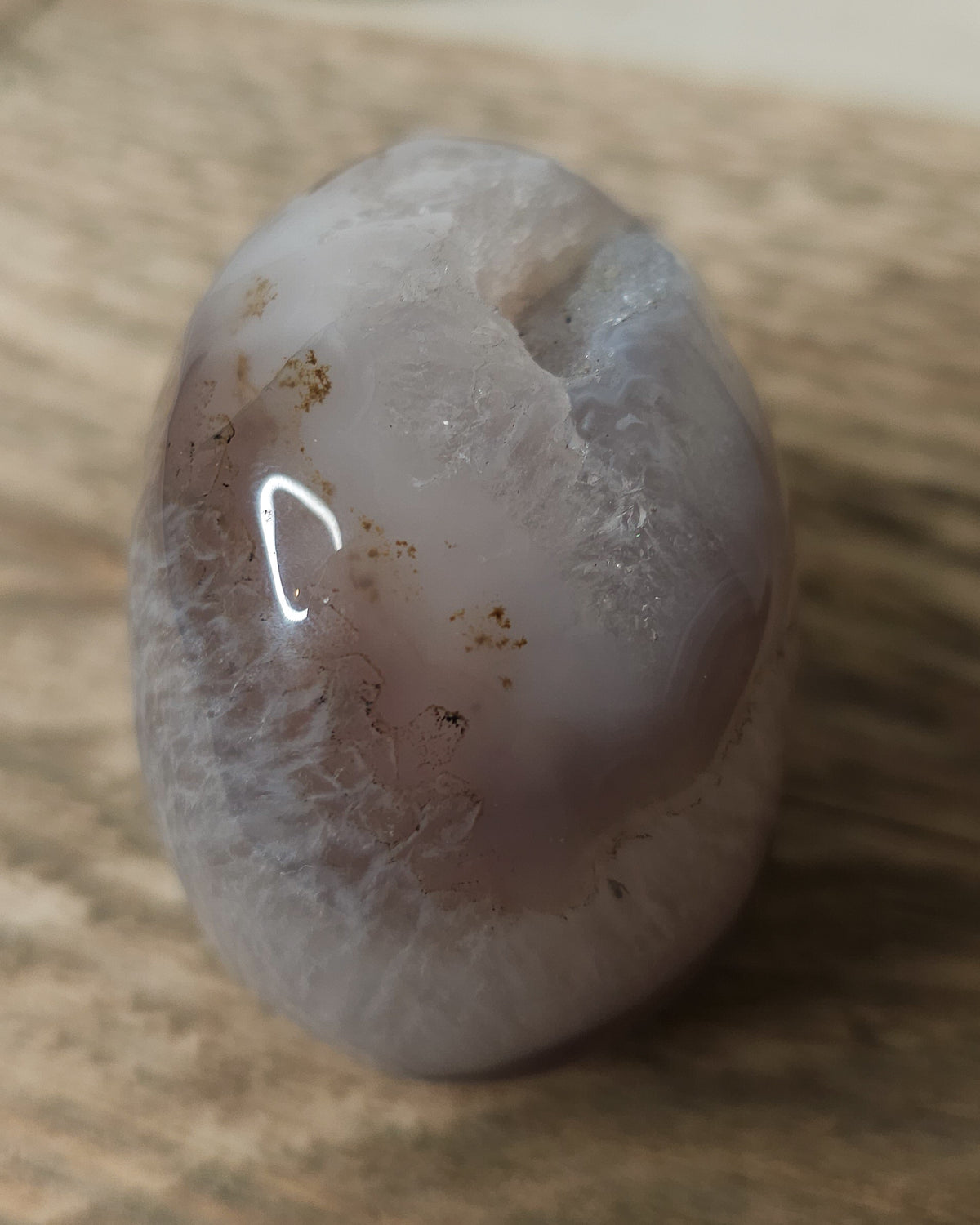 Druzy Agate crystal skull carving with translucent grey and lavender bands, deep purple areas, natural brown inclusions and a sparkling druzy crystal cavity on top.